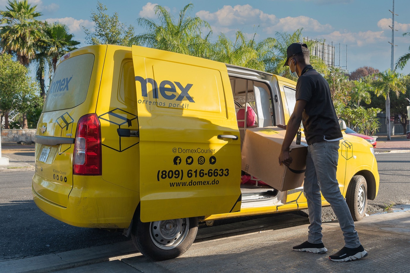 Camioneta de Domex cargando paquetes para salir a ruta